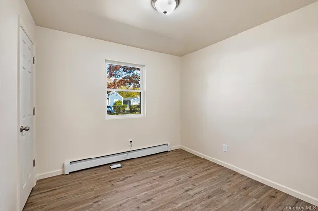 an empty room with wooden floor and window
