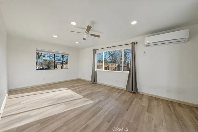 a view of an empty room with a window and wooden floor