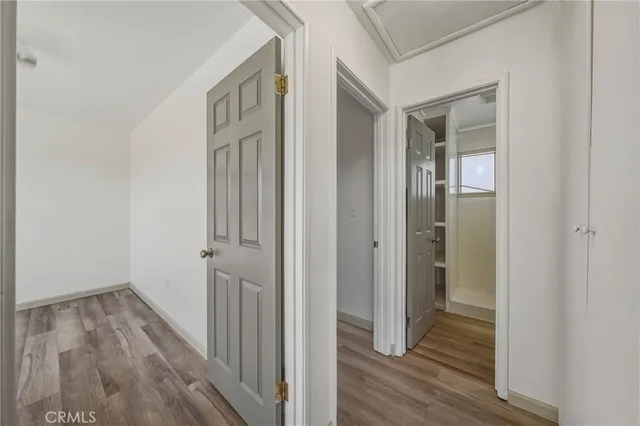 a view of a hallway with wooden floor and closet area