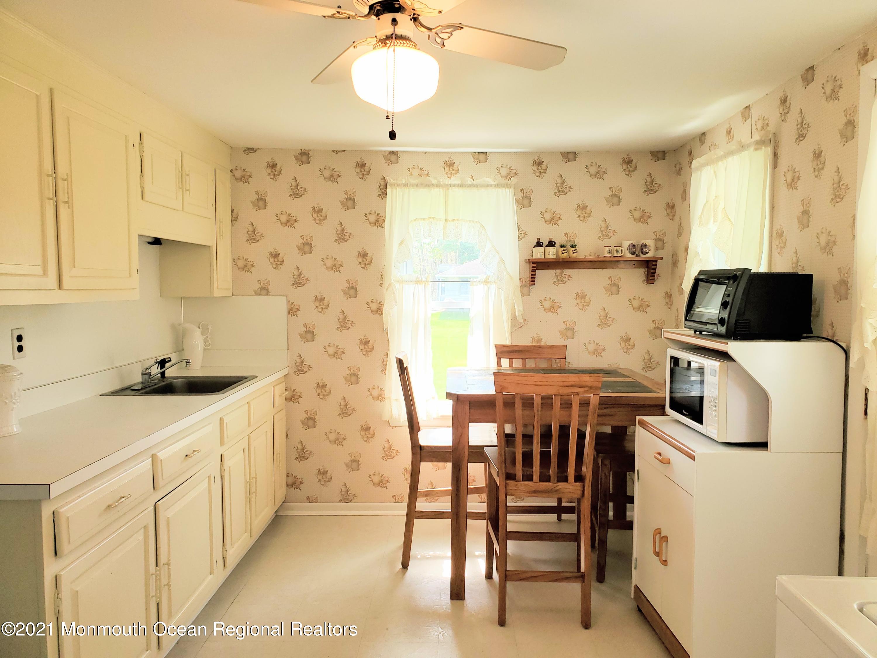 50 Hawkin Road Medford, NJ 08055 - Photo 8 of 28 a kitchen with stainless steel appliances a white table and chairs in it