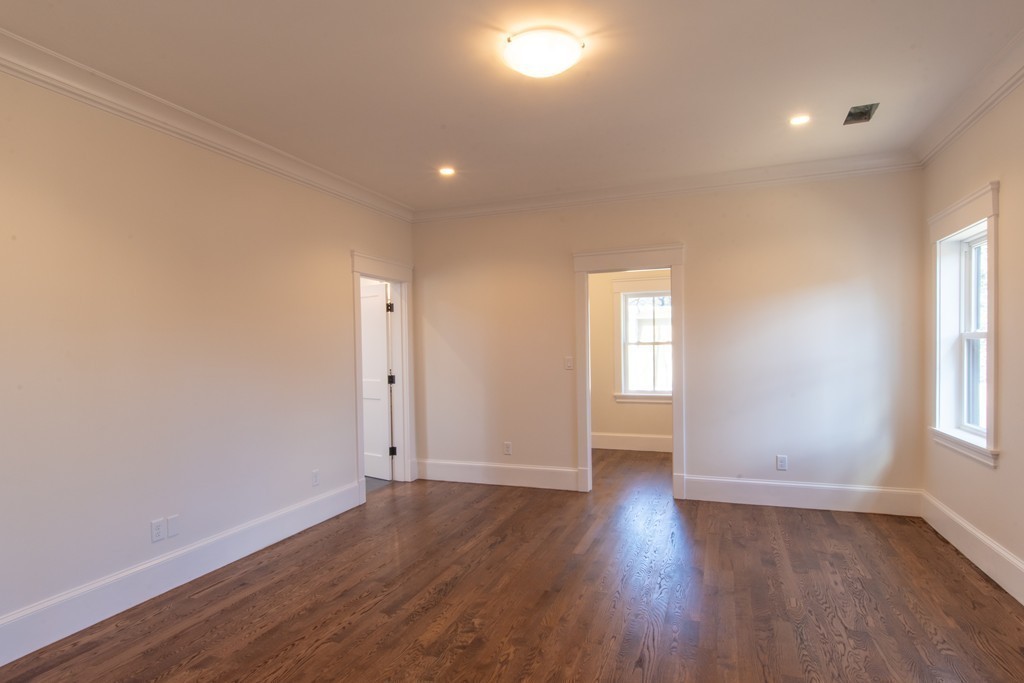 62 Maple Street, Unit 2 Needham, MA 02492 - Photo 12 of 25 an empty room with wooden floor and window