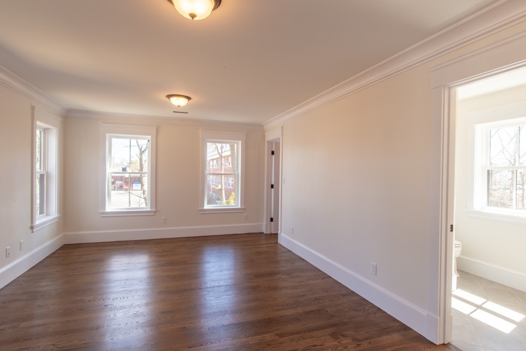 62 Maple Street, Unit 2 Needham, MA 02492 - Photo 16 of 25 a view of an empty room with wooden floor and a window