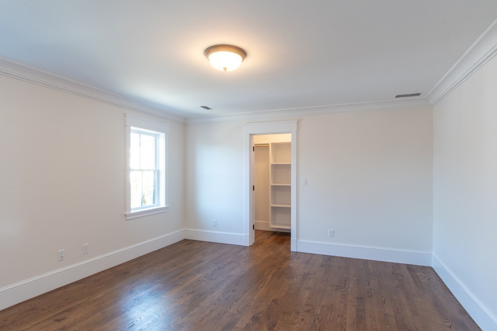62 Maple Street, Unit 2 Needham, MA 02492 - Photo 18 of 25 an empty room with wooden floor and windows