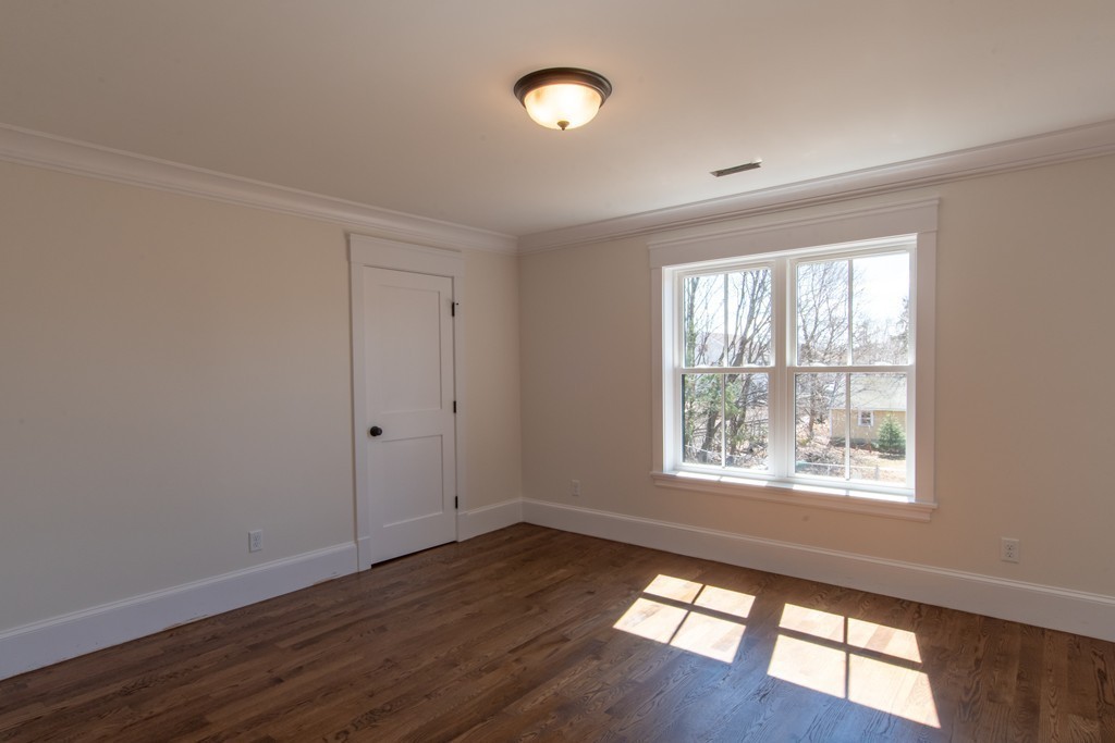 62 Maple Street, Unit 2 Needham, MA 02492 - Photo 19 of 25 a view of an empty room with wooden floor and a window