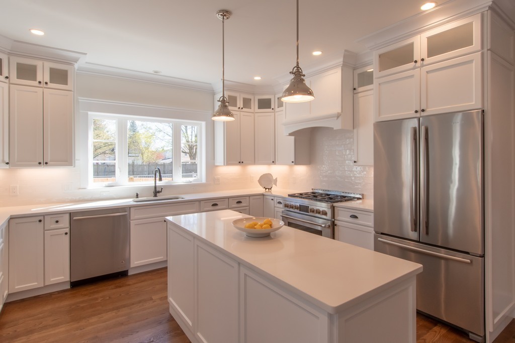 62 Maple Street, Unit 2 Needham, MA 02492 - Photo 4 of 25 a kitchen with stainless steel appliances granite countertop a refrigerator a sink dishwasher a stove and white countertops with wooden floor