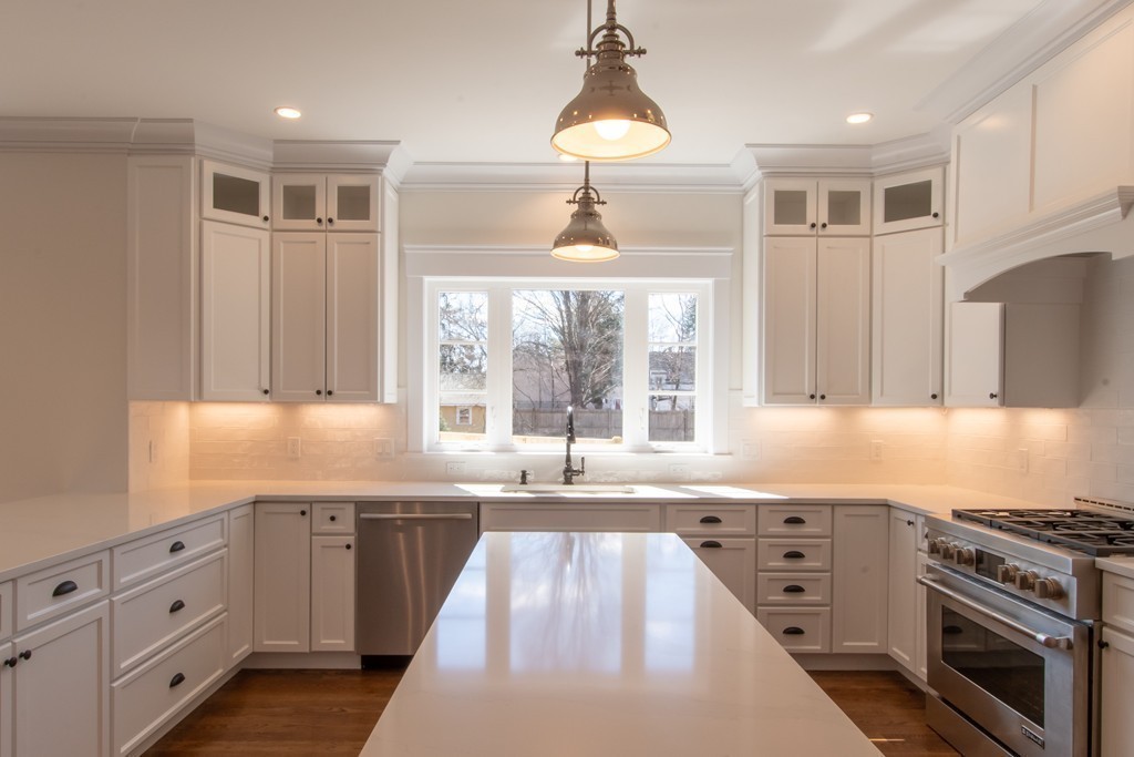 62 Maple Street, Unit 2 Needham, MA 02492 - Photo 5 of 25 a kitchen with granite countertop a stove a sink and a refrigerator
