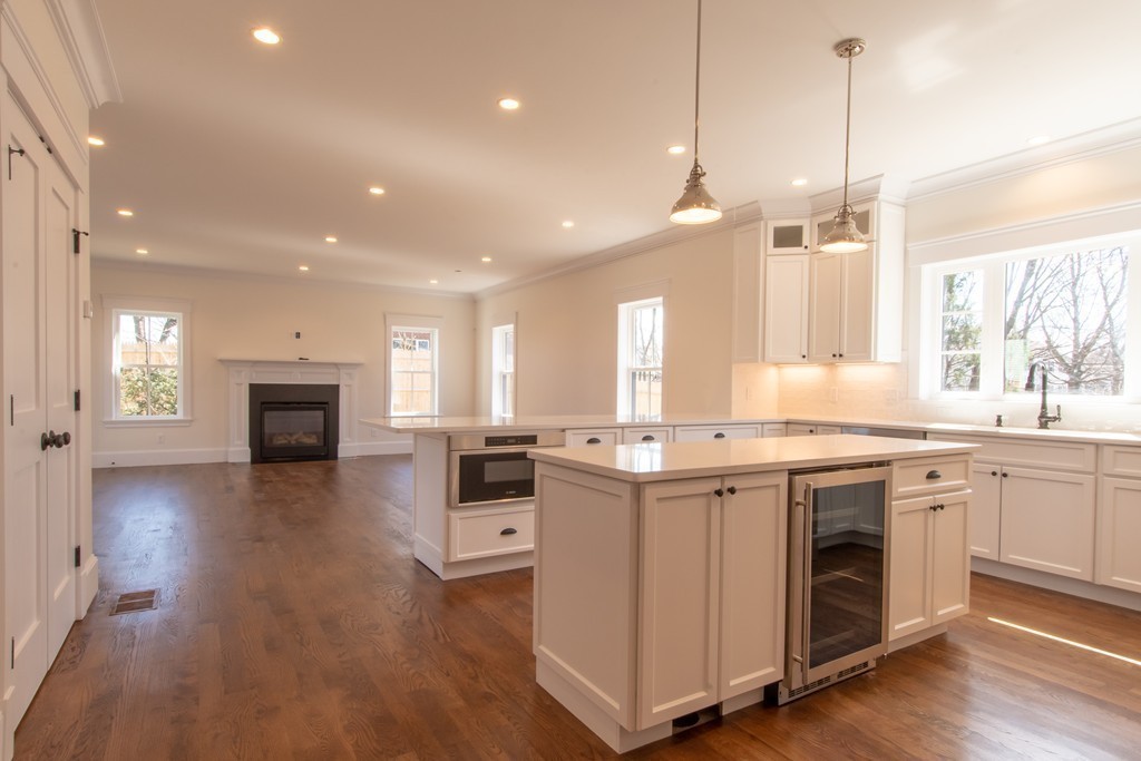 62 Maple Street, Unit 2 Needham, MA 02492 - Photo 9 of 25 a kitchen with kitchen island granite countertop a stove a sink a center island and a wooden floor
