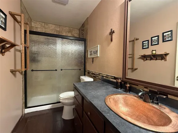 a bathroom with a granite countertop sink toilet and shower