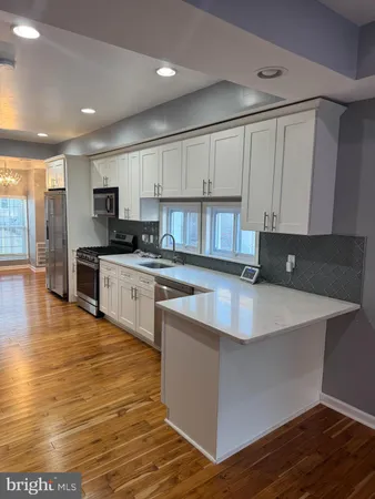 a large kitchen with stainless steel appliances granite countertop a stove a sink and a microwave