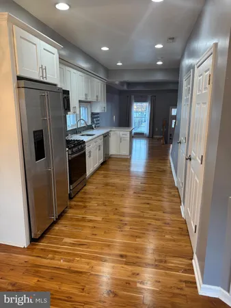 a view of a kitchen with a sink and refrigerator