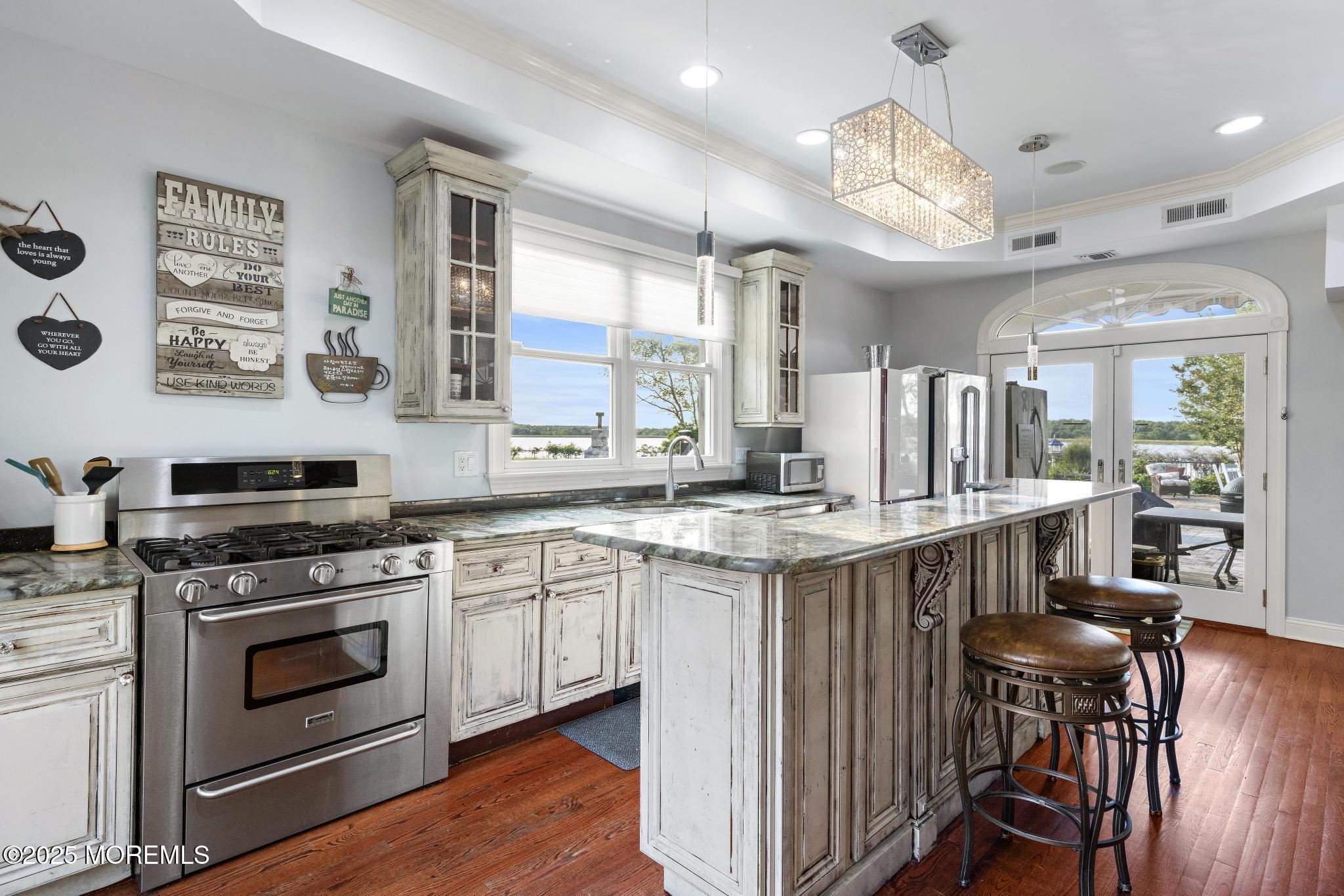 1413 Gully Road Wall, NJ 07719 - Photo 32 of 82 a kitchen with stainless steel appliances a stove a sink dishwasher and white cabinets with wooden floor