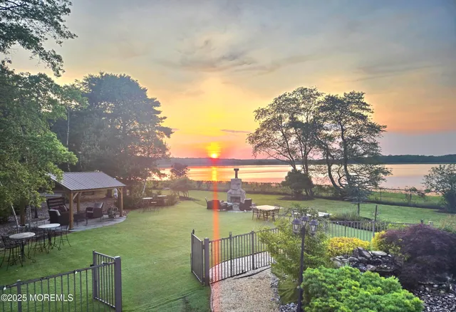 a front view of a house with a fountain and plants