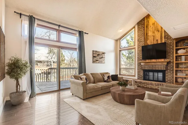 a living room with furniture a flat screen tv and a large window