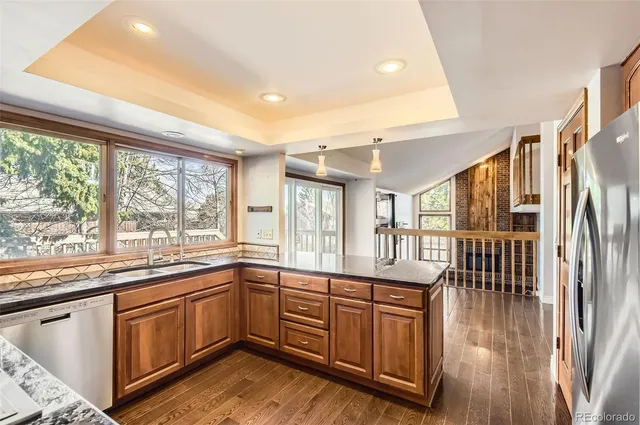 a kitchen with stainless steel appliances granite countertop a stove a sink and a refrigerator
