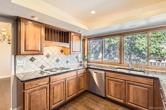 a kitchen with granite countertop stainless steel appliances a sink and a window