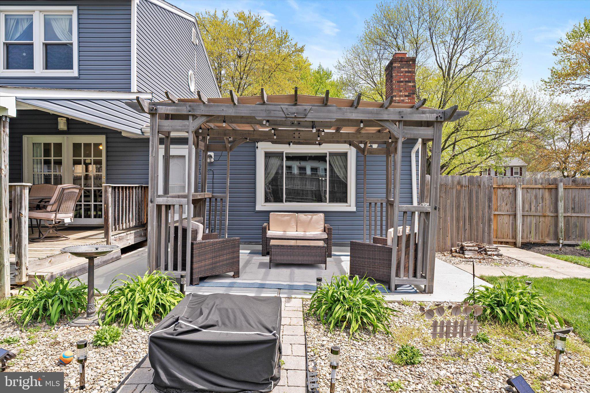 3 David Drive Ewing, NJ 08638 - Photo 27 of 32 a view of a patio with table and chairs potted plants and wooden fence