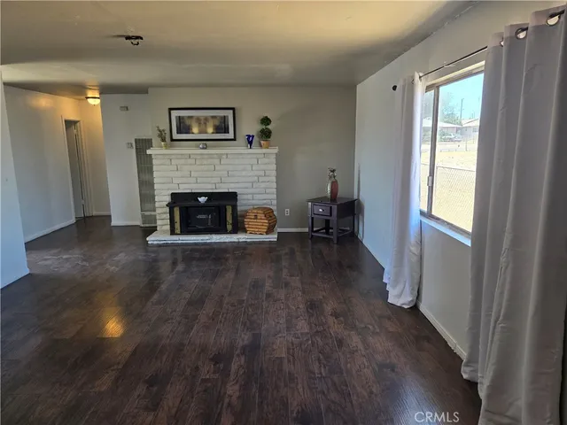 a living room with wooden floor and a fireplace