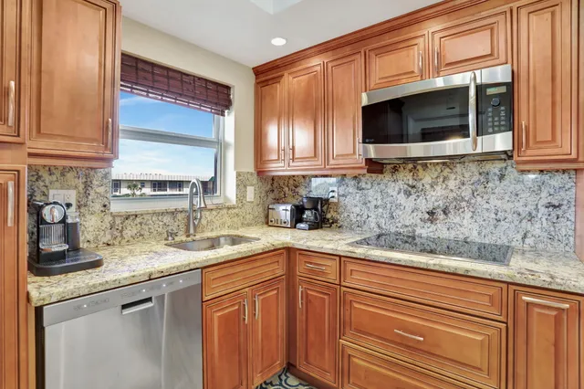 a kitchen with granite countertop a sink and a microwave