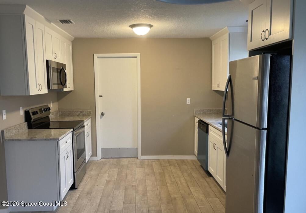 830 Angela Avenue, Unit B Rockledge, FL 32955 - Photo 2 of 9 a kitchen with a refrigerator a stove top oven a sink and dishwasher