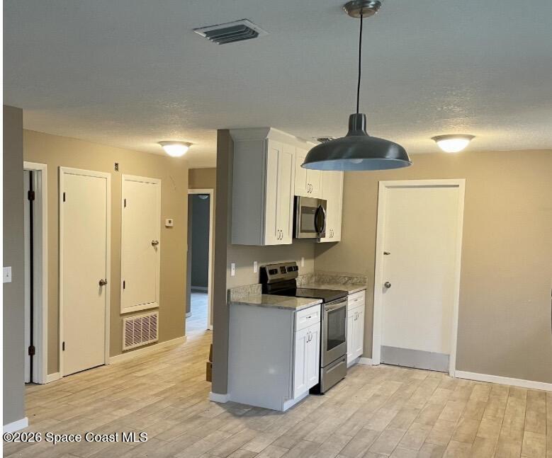 830 Angela Avenue, Unit B Rockledge, FL 32955 - Photo 4 of 9 a kitchen with stainless steel appliances a refrigerator sink and white cabinets