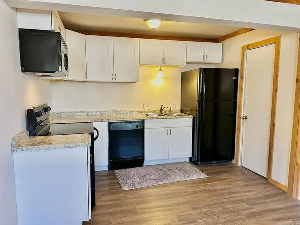 a kitchen with a sink a refrigerator and cabinets