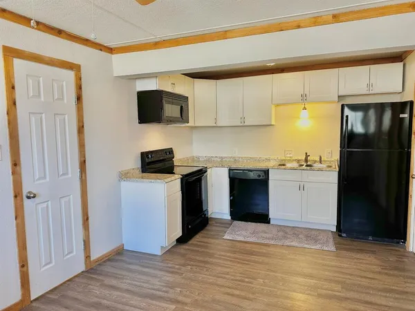 a kitchen with a refrigerator and a stove top oven