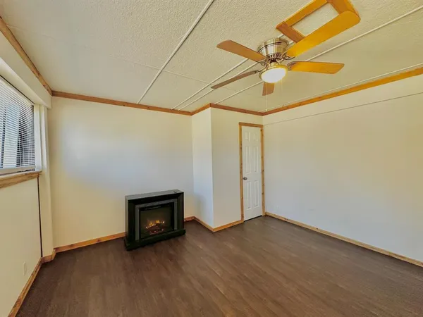 a view of an empty room with a fireplace and a window
