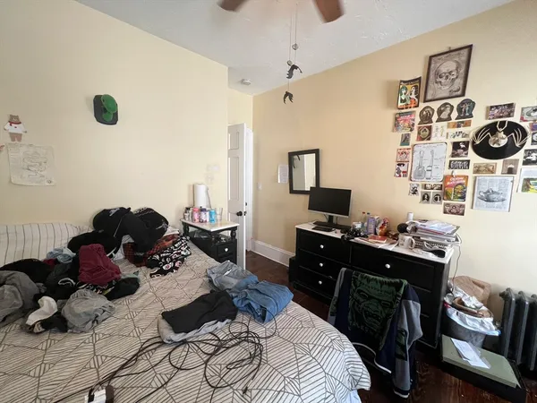 a bedroom with a bed and a computer on the desk