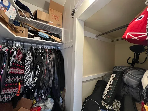 a view of walk in closet with clothes and shoes