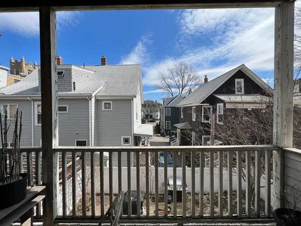 a view of a house with a small yard and wooden fence