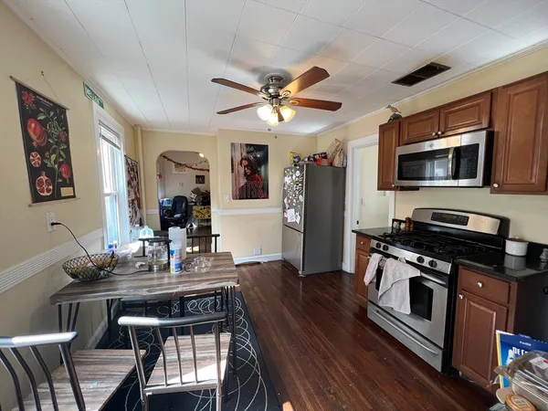 a dining room with wooden floor and stainless steel appliances