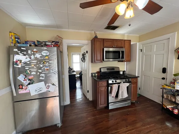 a kitchen with stainless steel appliances granite countertop a refrigerator a stove top oven a chimney and a refrigerator