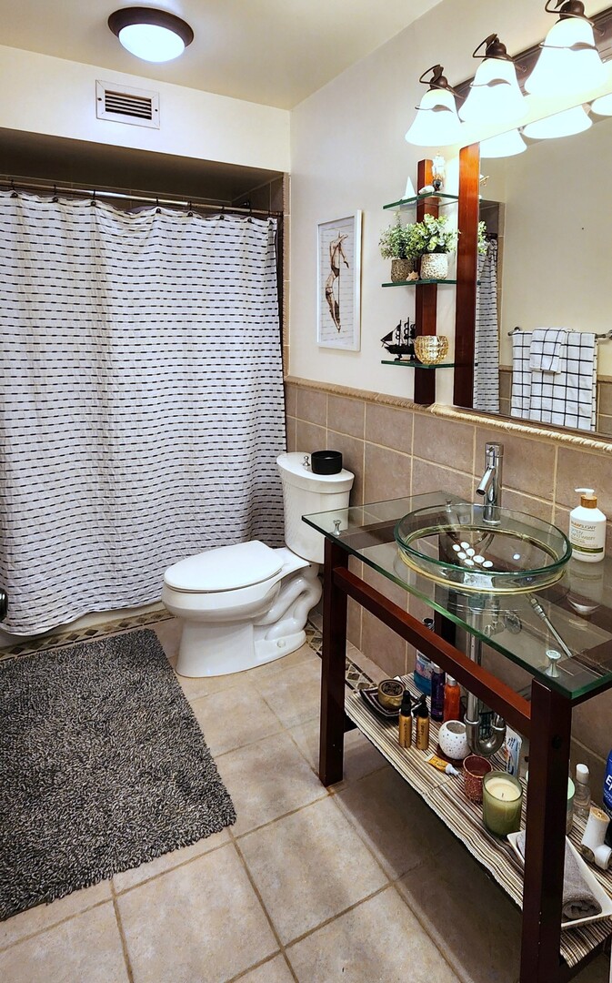 5901 North Sheridan Road, Unit 16C Chicago, IL 60660 - Photo 14 of 28 a bathroom with a sink a toilet and mirror