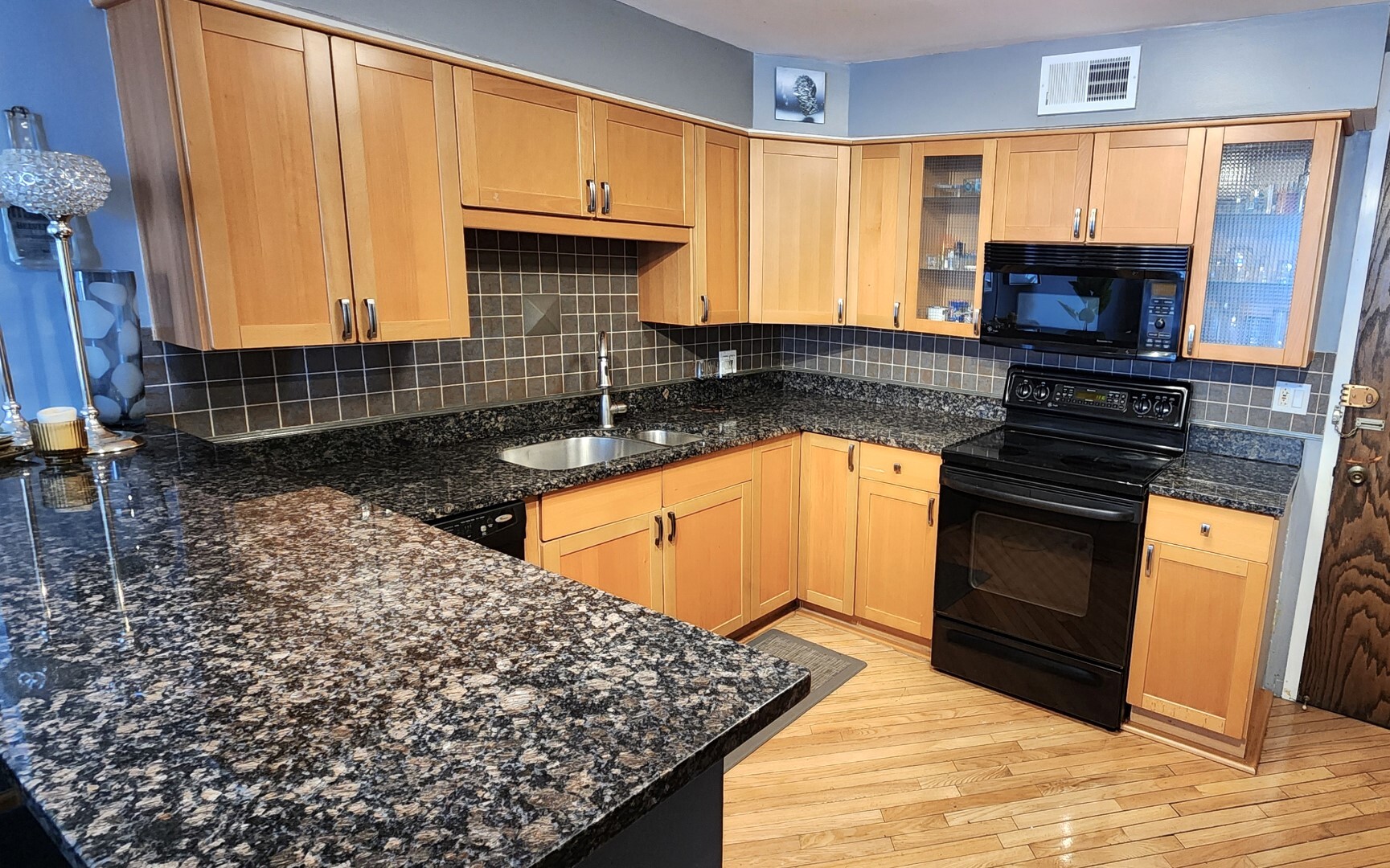 5901 North Sheridan Road, Unit 16C Chicago, IL 60660 - Photo 7 of 28 a kitchen with kitchen island granite countertop a sink stove and cabinets