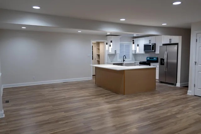 a view of kitchen with stainless steel appliances granite countertop a stove top oven and refrigerator