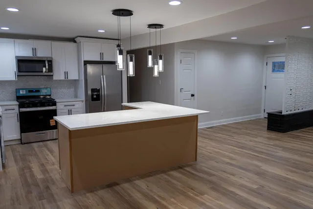 a kitchen with wooden floor and stainless steel appliances