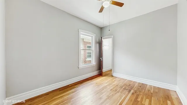 an empty room with a window and wooden floor