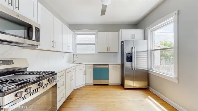 a kitchen with stainless steel appliances a stove a sink and a refrigerator