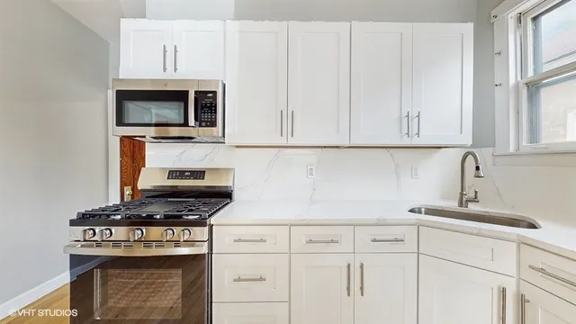 a kitchen with white cabinets and appliances