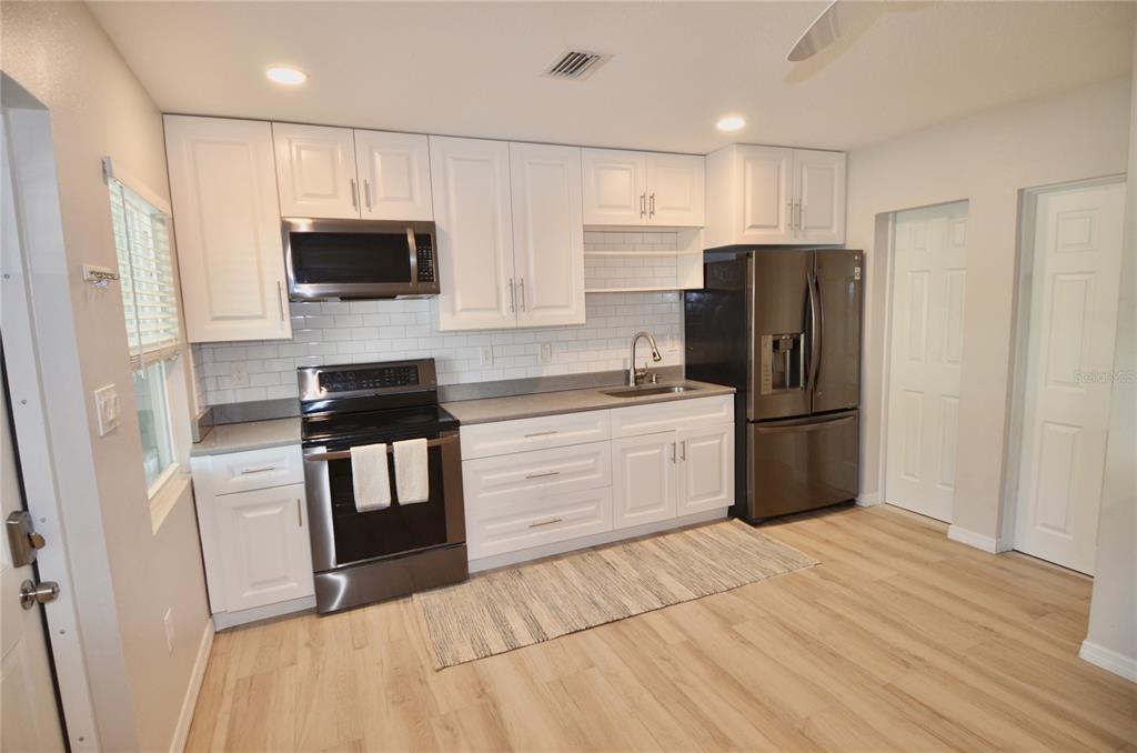 411 Pameto Road Nokomis, FL 34275 - Photo 15 of 85 a kitchen with a refrigerator a microwave and cabinets