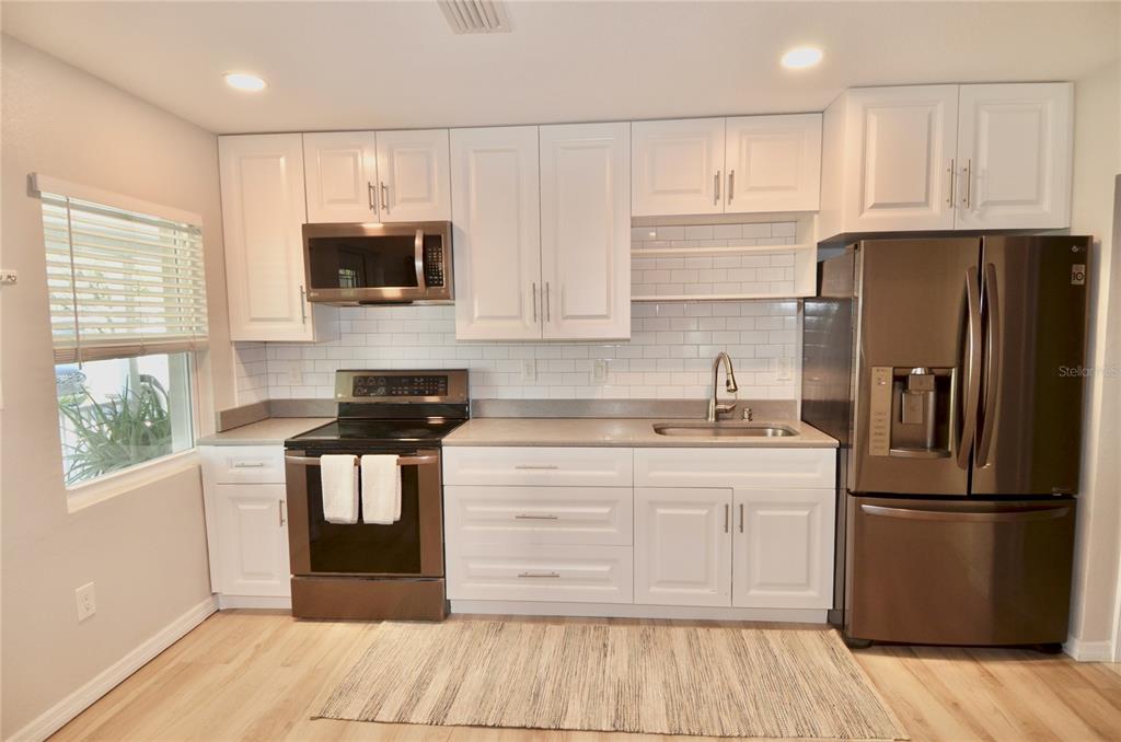 411 Pameto Road Nokomis, FL 34275 - Photo 16 of 85 a kitchen with a refrigerator stove and wooden cabinets