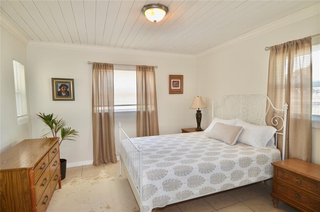 411 Pameto Road Nokomis, FL 34275 - Photo 47 of 85 a bedroom with a large bed and a potted plant