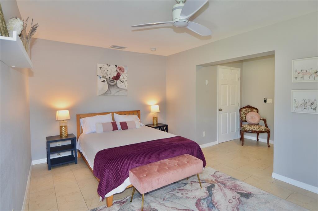 411 Pameto Road Nokomis, FL 34275 - Photo 7 of 85 a bedroom with a bed and a chandelier
