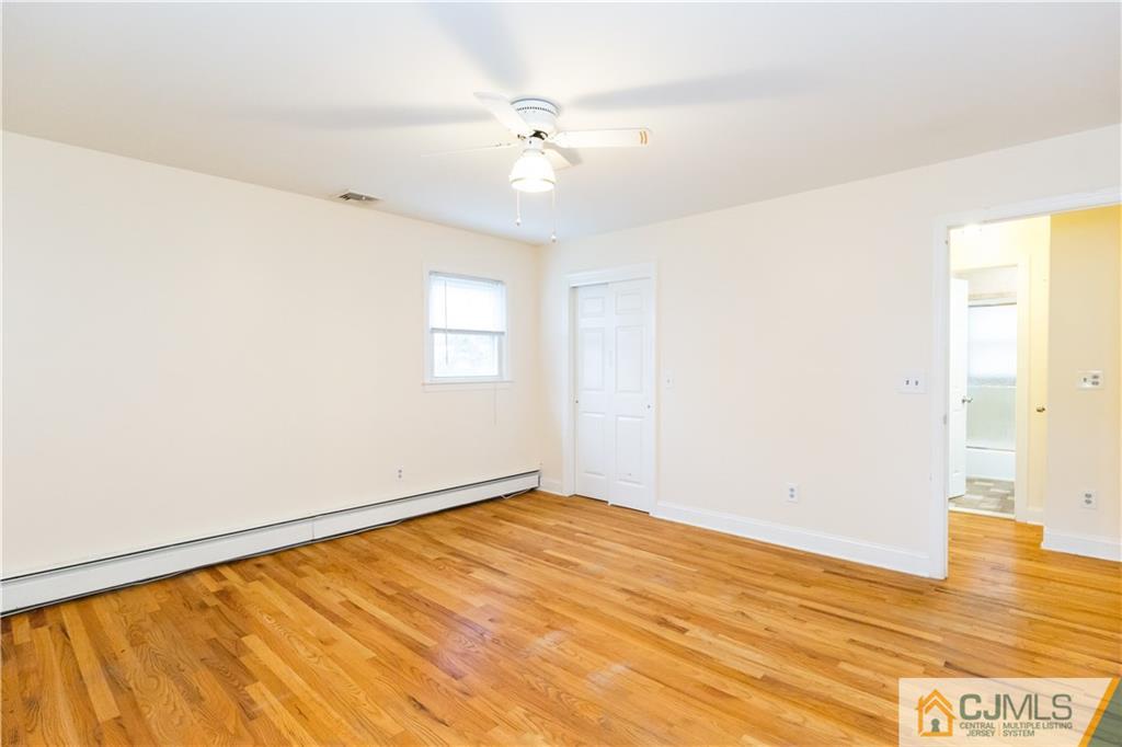 169 Old Post Road Edison, NJ 08817 - Photo 18 of 36 a view of an empty room with wooden floor and a window