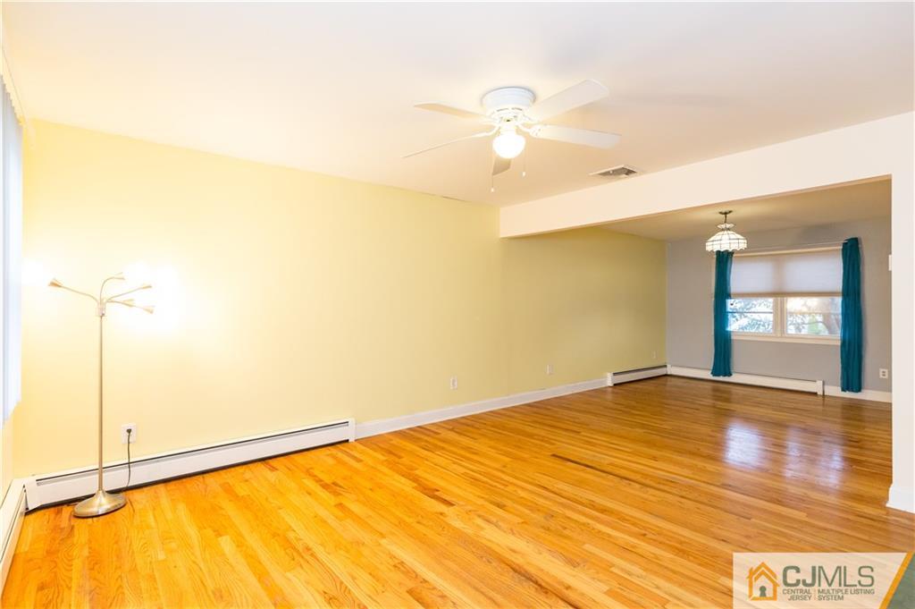 169 Old Post Road Edison, NJ 08817 - Photo 4 of 36 a view of an empty room with wooden floor and a window