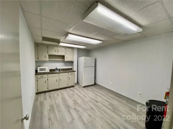 a kitchen with a sink a stove cabinets and a wooden floor