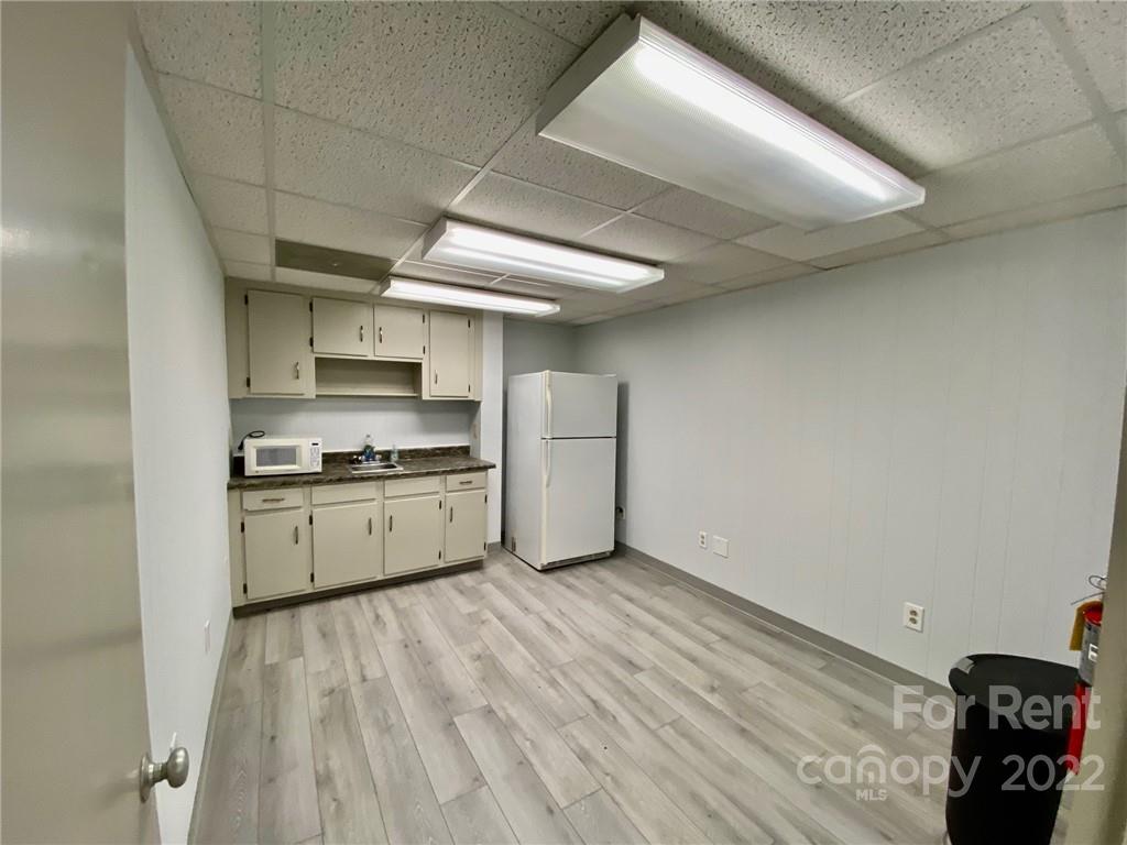 1119 2nd Street Northeast, Unit C Hickory, NC 28601 - Photo 6 of 16 a kitchen with a sink a stove cabinets and a wooden floor