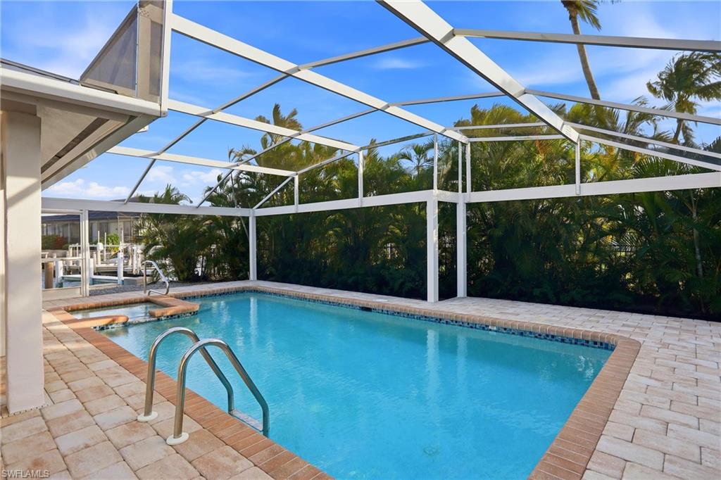 339 Landmark Street Marco Island, FL 34145 - Photo 42 of 50 View of pool featuring a sunroom, a patio, glass enclosure, and a pool with connected hot tub