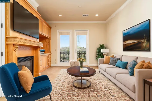 a living room with furniture a flat screen tv and a fireplace