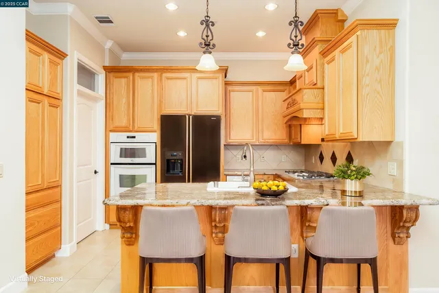 a kitchen with kitchen island granite countertop a sink cabinets and stainless steel appliances